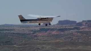 AX139_024 - 5.5K aerial stock footage of tracking Cessna flying over a desert, Grand County, Utah