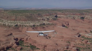 AX139_028 - 5.5K aerial stock footage of tracking a Cessna over desert and approaching rock formations, Grand County, Utah