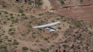 AX139_030 - 5.5K aerial stock footage of a Cessna over desert rock formations, Grand County, Utah