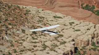 AX139_030E - 5.5K aerial stock footage of tracking a Cessna as it flies over desert, Grand County, Utah