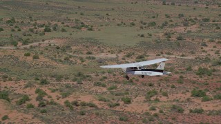 AX139_032 - 5.5K aerial stock footage of tracking a Cessna as it flies over desert, Grand County, Utah