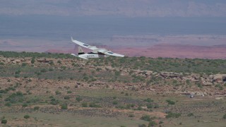 AX139_033 - 5.5K aerial stock footage of tracking a Tecnam P2006T over desert, Grand County, Utah
