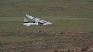 AX139_034 - 5.5K aerial stock footage of a Tecnam P2006T flying over the desert, Grand County, Utah