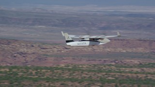 AX139_035 - 5.5K aerial stock footage track a Tecnam P2006T flying over desert valley, Grand County, Utah