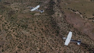 AX139_043 - 5.5K aerial stock footage of a Tecnam P2006T and Cessna flying over desert, Grand County, Utah