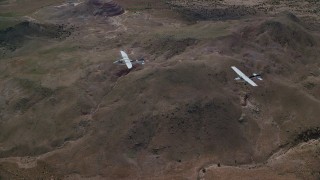AX139_045 - 5.5K aerial stock footage of Tecnam P2006T and Cessna planes flying over desert, Grand County, Utah
