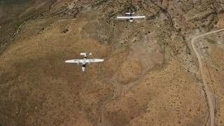 AX139_046 - 5.5K aerial stock footage of two planes, Tecnam P2006T and Cessna, flying over desert, Grand County, Utah