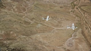 AX139_047 - 5.5K aerial stock footage of Tecnam P2006T, Cessna flying over desert, Grand County, Utah