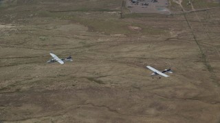 AX139_048 - 5.5K aerial stock footage of a pair of airplanes, a Tecnam P2006T and a Cessna, flying over desert, Grand County, Utah