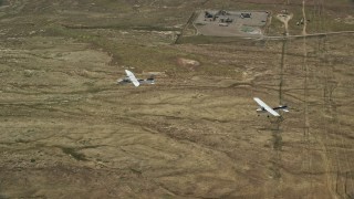 AX139_048E - 5.5K aerial stock footage of Tecnam P2006T and Cessna flying above the desert, Grand County, Utah