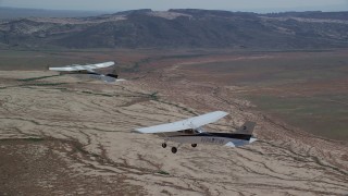 AX139_054 - 5.5K aerial stock footage of flying beside Tecnam P2006T and Cessna flying over desert, Grand County, Utah