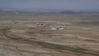 AX139_058 - 5.5K aerial stock footage of flying beside a Tecnam P2006T and Cessna flying over desert, Grand County, Utah