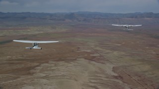 AX139_060 - 5.5K aerial stock footage of flying around Tecnam P2006T, Cessna flying over desert, Grand County, Utah
