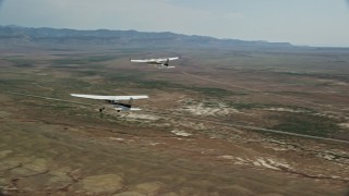 AX139_060E - 5.5K aerial stock footage of flying around Tecnam P2006T, Cessna flying over desert, Grand County, Utah