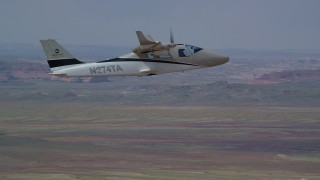 AX139_064 - 5.5K aerial stock footage track a Tecnam P2006T flying over desert, Grand County, Utah