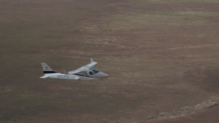 AX139_067 - 5.5K aerial stock footage of tracking Tecnam P2006T flying over desert, revealing Cessna, Grand County, Utah