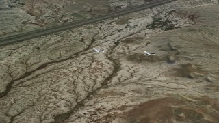 AX139_069E - 5.5K aerial stock footage of Tecnam P2006T, Cessna over desert highway, Grand County, Utah