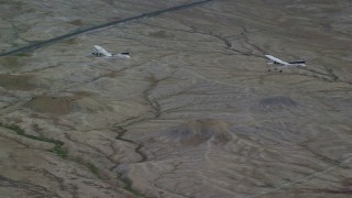 AX139_070 - 5.5K aerial stock footage of Tecnam P2006T, Cessna over desert highway, Grand County, Utah