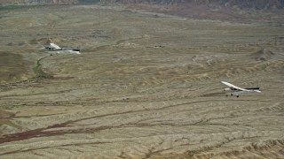AX139_073E - 5.5K aerial stock footage focus on Tecnam P2006T and Cessna flying over desert, Grand County, Utah