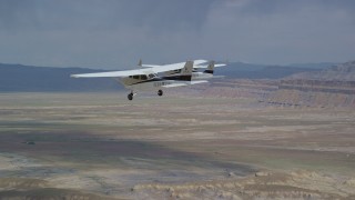 AX139_083 - 5.5K aerial stock footage track Tecnam P2006T and Cessna flying over desert, Grand County, Utah