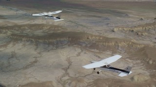 AX139_084 - 5.5K aerial stock footage of flying near Tecnam P2006T and Cessna over desert, Grand County, Utah