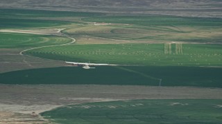 AX139_087E - 5.5K aerial stock footage of a Tecnam P2006T near circular crop fields, reveal Cessna, Green River, Utah