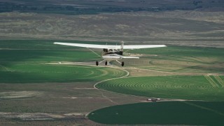 AX139_089E - 5.5K aerial stock footage tracking Cessna airplane over circular crop fields, Green River, Utah