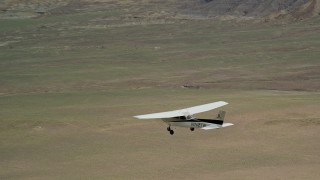 AX139_094E - 5.5K aerial stock footage focus on a Cessna airplane over circular crop fields, Green River, Utah