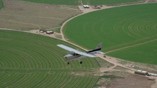 AX139_096 - 5.5K aerial stock footage of a Cessna over circular crop fields, Green River, Utah