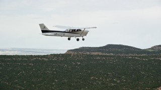 AX139_115 - 5.5K aerial stock footage of tracking a Cessna flying over desert mesas, Emery County, Utah