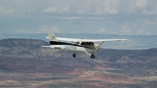 AX139_133E - 5.5K aerial stock footage of a view of a Cessna flying high above desert, ascend out of frame, Emery County, Utah