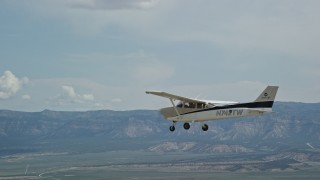 AX139_150E - 5.5K aerial stock footage track a Cessna flying over desert, ascend to bird's eye view of plane, Carbon County, Utah