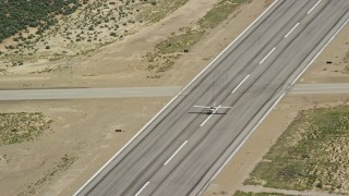 AX140_001E - 5.5K aerial stock footage of a Cessna flying away from airport after take off, Buck Davis Field, Utah