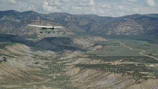 AX140_007E - 5.5K aerial stock footage of a Cessna plane over desert, approaching distant mountains, Carbon County, Utah
