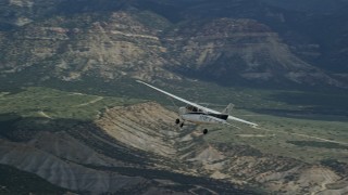 AX140_009E - 5.5K aerial stock footage of a Cessna aircraft over desert, partly cloudy, distant mountains, Carbon County, Utah