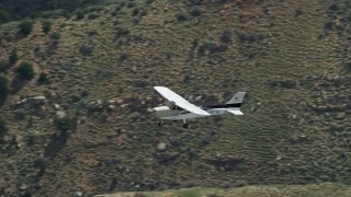 AX140_017E - 5.5K aerial stock footage of a Cessna in flight over desert mountains, Carbon County, Utah