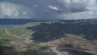 AX140_037 - 5.5K aerial stock footage of mountains, Highway 6, Colton ghost town, clouds, Wasatch Range, Utah County, Utah