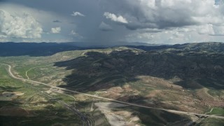 AX140_037E - 5.5K aerial stock footage of a wide view of mountains and Highway 6, Colton ghost town, clouds, Wasatch Range, Utah County, Utah