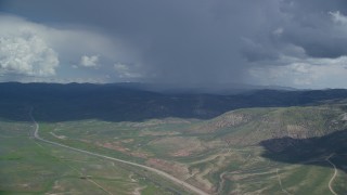 AX140_041 - 5.5K aerial stock footage of tracking a Tecnam P2006T near rainstorm and Highway 6, Wasatch Range, Utah County, Utah