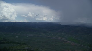 AX140_049 - 5.5K aerial stock footage of a Tecnam P2006T and Cessna flying by rainstorm and Highway 6, Wasatch Range, Utah