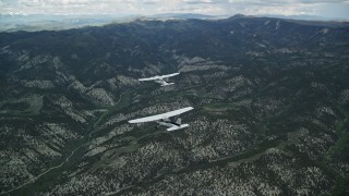 AX140_068E - 5.5K aerial stock footage tracking Tecnam P2006T flying ahead of Cessna over mountains, Wasatch Range, Utah