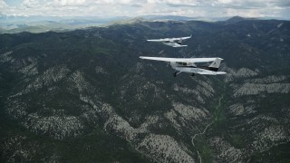 AX140_071E - 5.5K aerial stock footage of following a Cessna tailing a Tecnam P2006T over the Wasatch Range, Utah