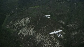 AX140_074E - 5.5K aerial stock footage of a Tecnam P2006T leading a Cessna over Wasatch Range, Utah