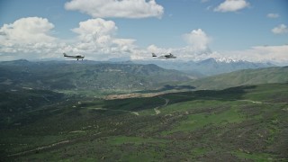 AX140_083 - 5.5K aerial stock footage of aTecnam P2006T and Cessna over mountains near winding road, Wasatch Range, Utah