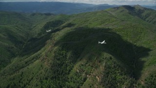 AX140_094E - 5.5K aerial stock footage of tracking a Tecnam P2006T as it flies over mountains, zoom in, Wasatch Range, Utah