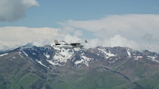 AX140_103E - 5.5K aerial stock footage of tracking Tecnam P2006T near snowy Freedom Peak, Wasatch Range, Utah