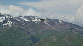 AX140_105 - 5.5K aerial stock footage of a Tecnam P2006T flying near snowy Freedom Peak, Wasatch Range, Utah