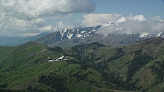 AX140_116E - 5.5K aerial stock footage of a bird's eye view of a Tecnam P2006T airplane flying over mountains, Wasatch Range, Utah
