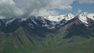 AX140_127E - 5.5K aerial stock footage fly around tail section of Tecnam P2006T near snowy peak and green mountains, Wasatch Range, Utah