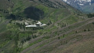 AX140_145E - 5.5K aerial stock footage of flying with a Tecnam P2006T passing green and purple mountains, aspen trees, Wasatch Range, Utah
